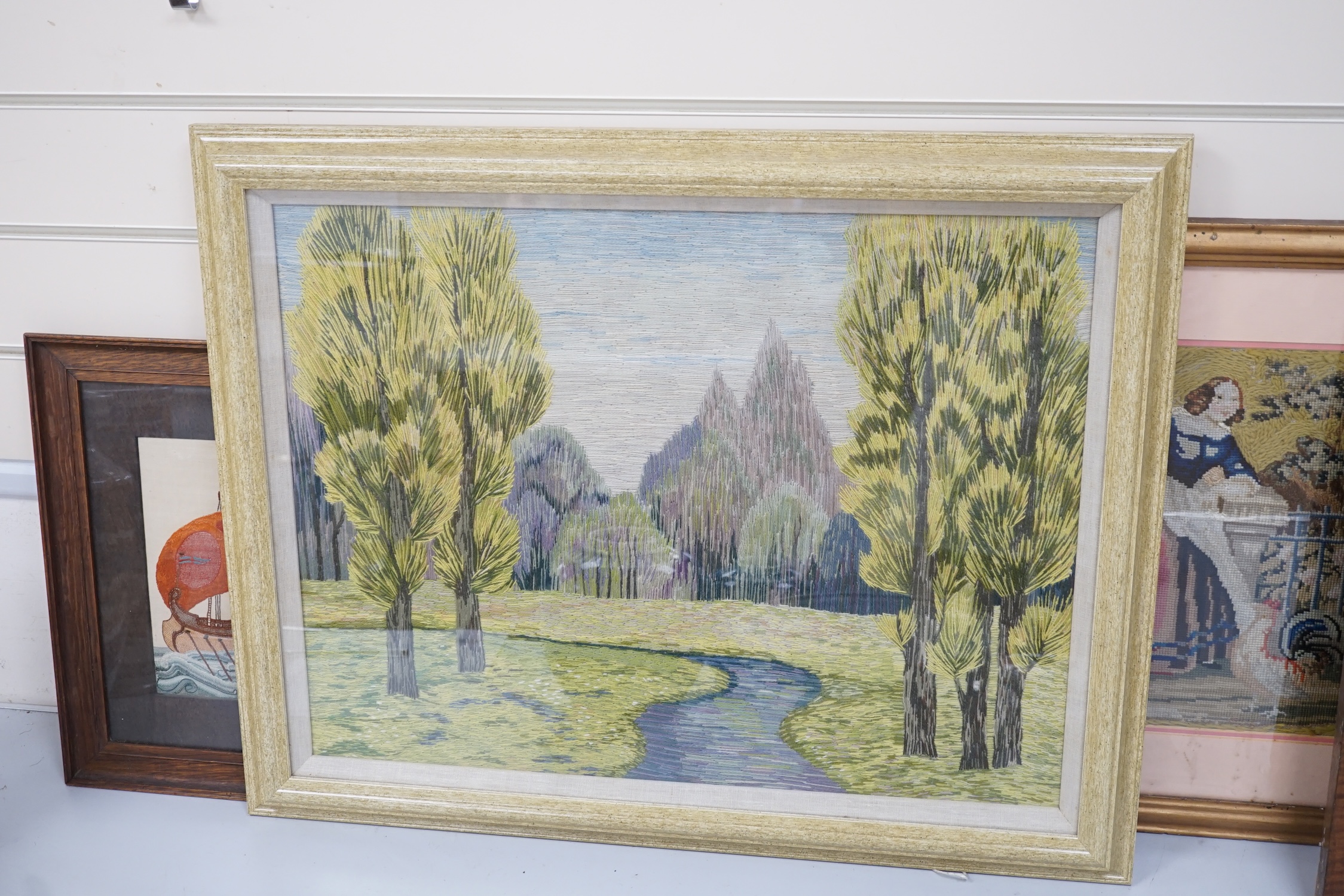 19th century and later framed embroideries (5); a 19th century wool worked still life embroidery, a later similar silk embroidery, a figurative wool worked embroidery, silk embroidery of a galleon and a landscaped wool w